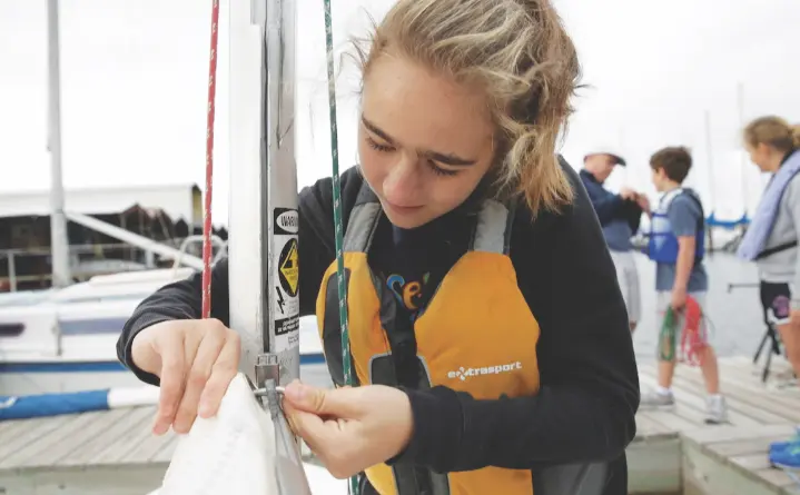 Young girl learning how to tie sailing knot